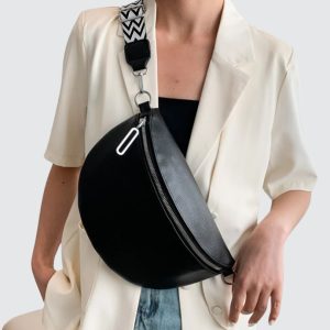 Femme portant un sac banane en cuir noir grand format pour voyage et style
